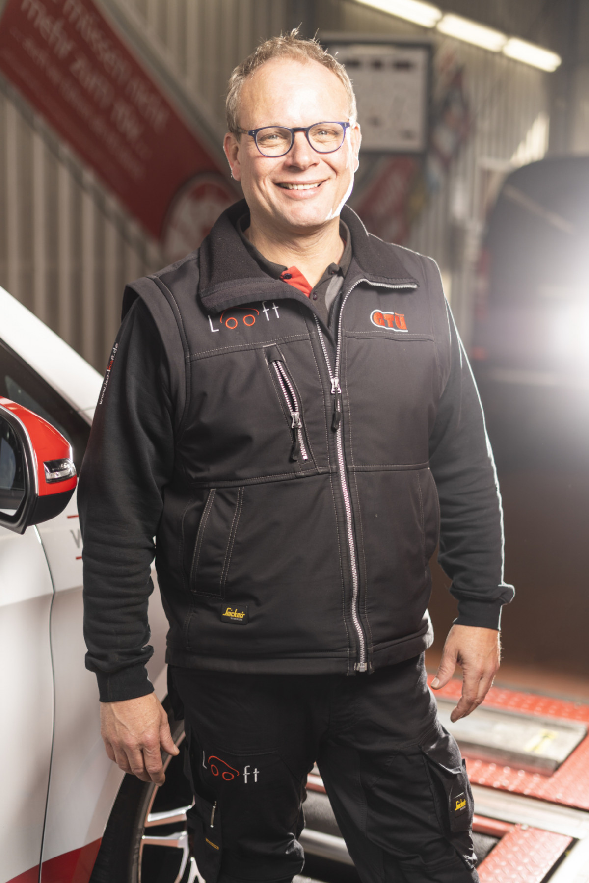 Andreas Looft steht in Arbeitskleidung in der Werkstatt
