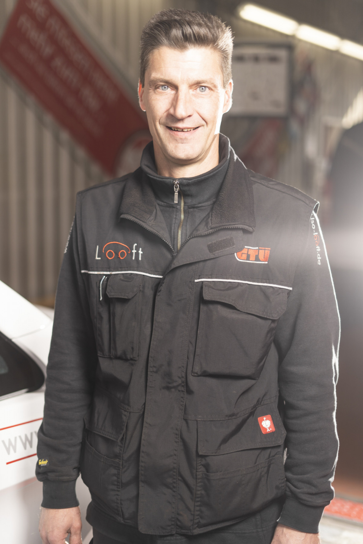 Daniel Suhr steht in Arbeitskleidung in der Werkstatt